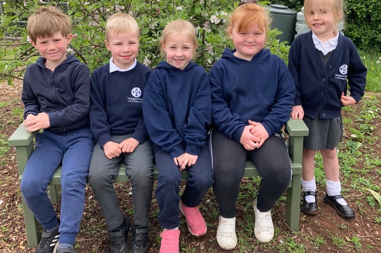 Farrington Gurney school children sitting on their new bench, thanks to Midsomer Norton Men’s Shed. 