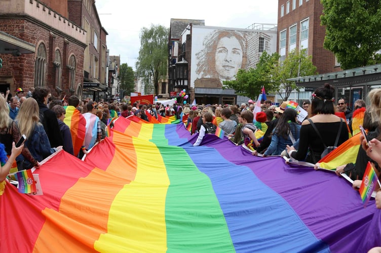 A rainbow flag being carried down Exeter High Street at a previous Exeter Pride.  AQ 1024