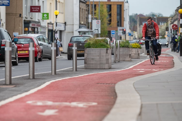 GV of the cycle lane on High Street, Keynsham SWNS story SWLNlane. An 'optical illusion' has injured nearly 60 cyclists on poorly-designed cycle lane. A recent freedom of information request showed that a staggering 59 people were injured on the lane on Keynsham High Street in Bristol. Photos of the lane, which installed last March shows how the lane appears to be flat at a glance - but actually passes over an elevated pedestrian crossing. Cyclists have repeatedly missed the 'bump' in the road, throwing them off their bikes as they hit it at speed - which one City Councillor is warning could lead to deaths.  