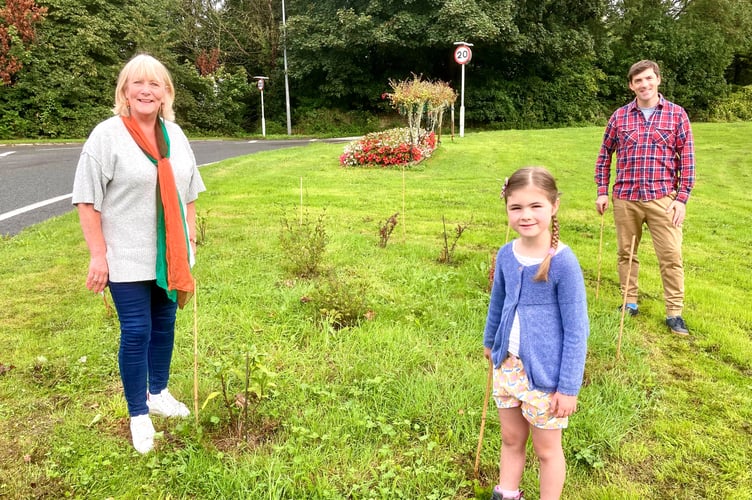 Pictured is Cllr Karen Walker (left) with seven-year-old Lucie and her dad Jamie at the southern-end of Peasedown St John where new shrubs have been planted. 