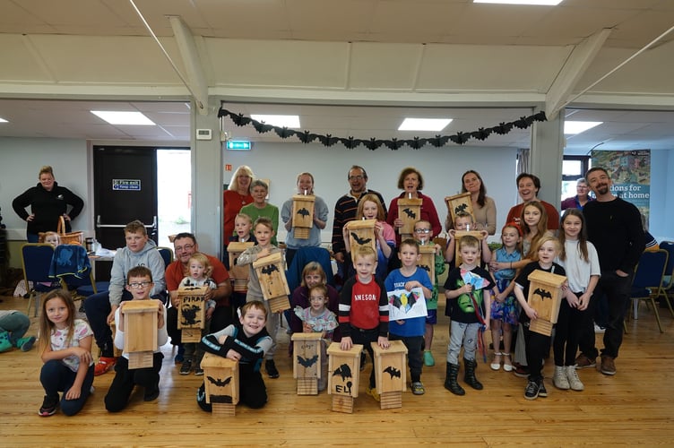 Children proudly display the bat boxes they created during the community event.