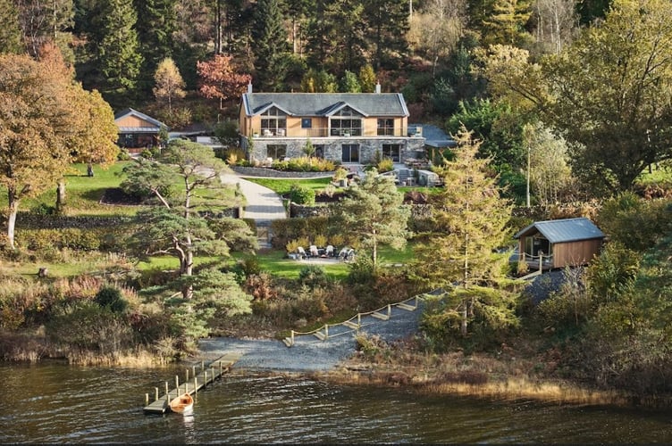 The property includes 200 metres of lake frontage, a private wood-panelled jetty, and six acres of natural woodland with free-flowing streams, making it an ideal setting for outdoor enthusiasts.

