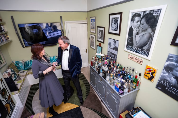 Ian and Yvette Perryman from Bristol who have turned their front room into an art deco picture house - covered in memorabilia and a gin bar with 80 different bottles. Photo released March 4 2025. Monday nights have been renamed Martini Mondays - when they sit down to watch a classic film from the black and white movie era with a glass of dry Martini.