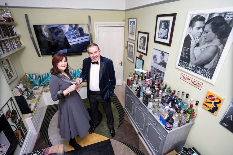 Ian and Yvette Perryman from Bristol who have turned their front room into an art deco picture house - covered in memorabilia and a gin bar with 80 different bottles. Photo released March 4 2025. Monday nights have been renamed Martini Mondays - when they sit down to watch a classic film from the black and white movie era with a glass of dry Martini.